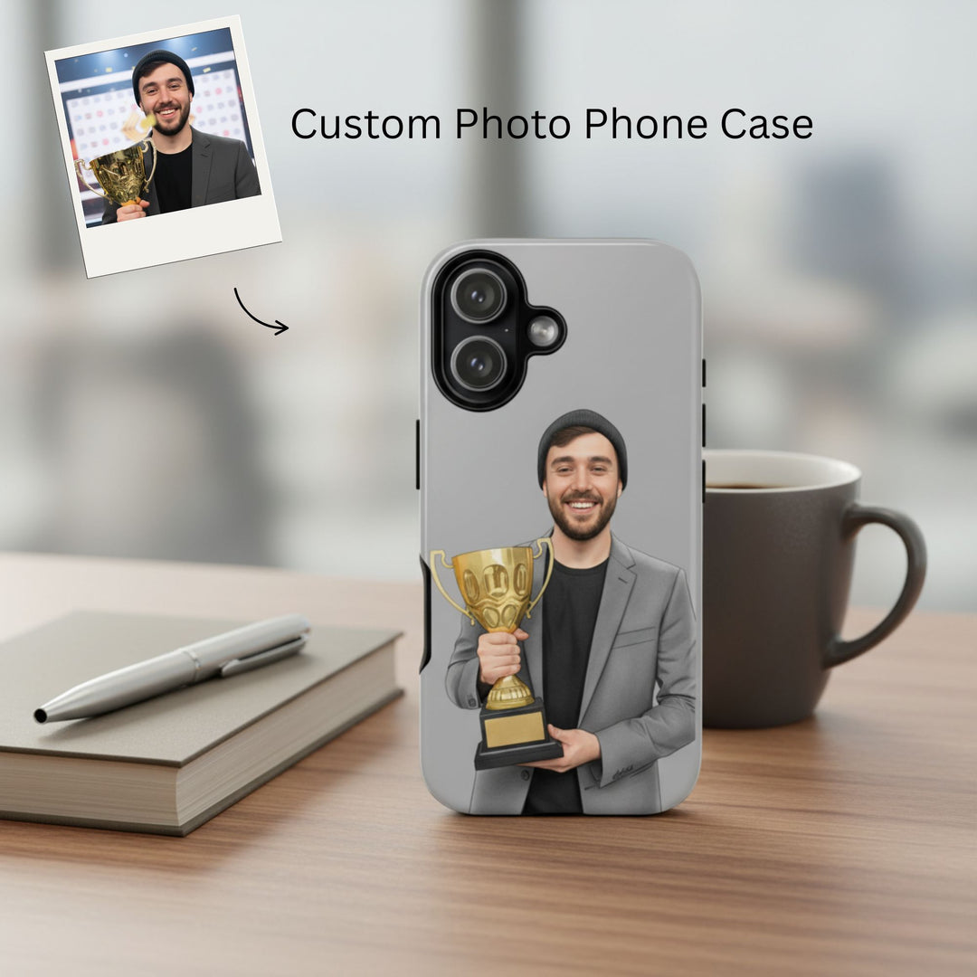 Phone case with a photo of a man holding a trophy, placed on a desk with a cup and pen.